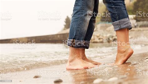 Closeup Of A Couples Legs While Embracing On The Beach Stock Photo