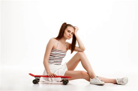 Jeune Jolie Fille Posant Avec Planche à Roulettes Sur Mur Blanc Photo