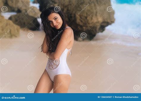 Beautiful Tanned Girl In White Swimsuit Resting On Beach Stock Image