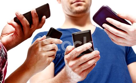 Four People Busy Checking Their Mobile Phone Screens Stock Photo