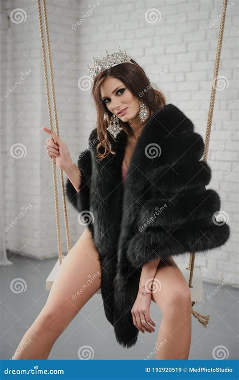 Photo Of A Fashion Woman In Black Fur Coat With Beige Collar In Pink Underwear With A Crown On