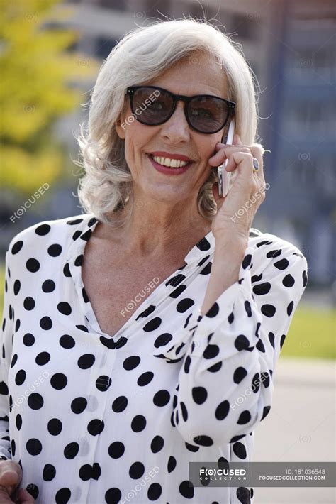 Portrait Of Smiling Senior Woman Wearing Sunglasses Telephoning With Smartphone — Close Up