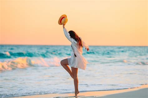 Mujer Hermosa Joven En La Playa Tropical En Puesta De Sol Foto Premium