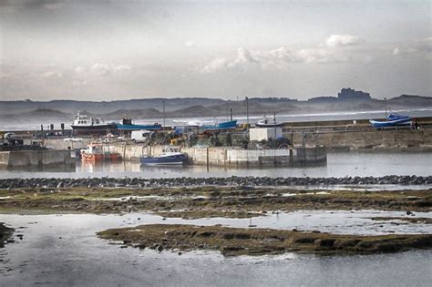 Seahouses Harbour In Northumberland With Bamburgh Castle Stock Image