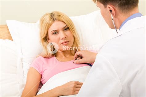 Photo Of Sad Woman Lying In Bed While Male Doctor Examining Her With