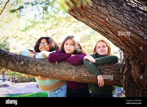 Three Pretty Tween Girls Laughing Together Outdoors In Fall Colors