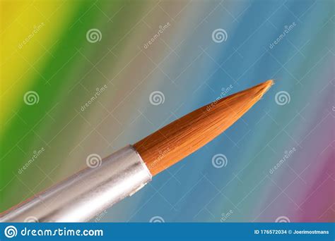 A Macro Portrait Of A Paintbrush Tip In Front Of A Colorful Background