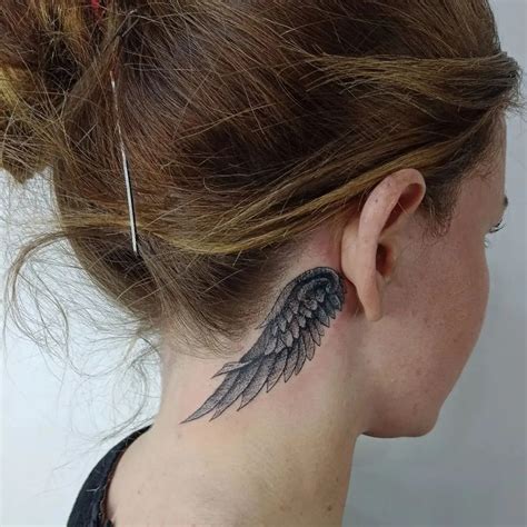 A Womans Neck With An Angel Wing Tattoo On Her Left Upper Back Side