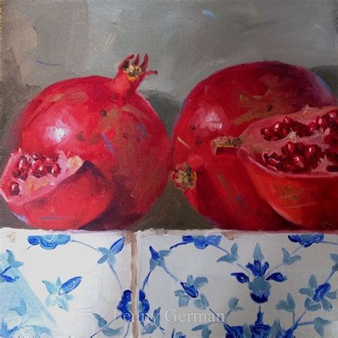 Two Pomegranates Sitting On Top Of Each Other In Front Of A Blue And