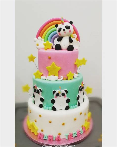 A Three Tiered Cake Decorated With Panda Bears And Rainbows