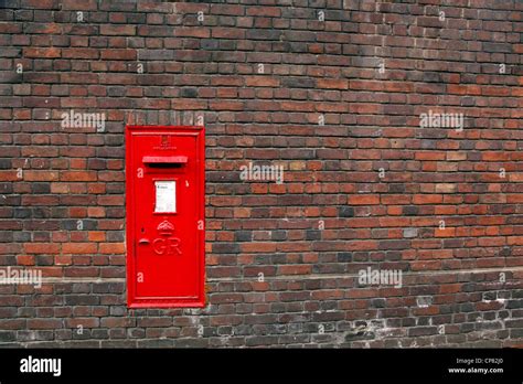 Red English Post Box In A Brick Wall In Cambridge England Stock Photo