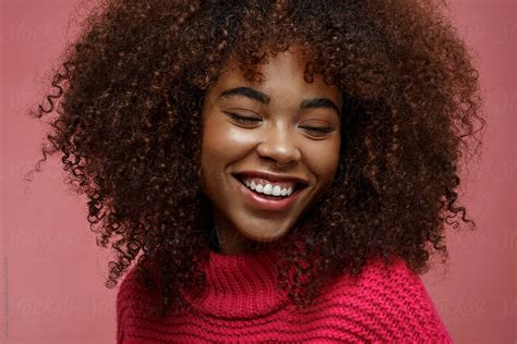 Portrait Of A Young African American Afro Woman In Pink Studio Smiling