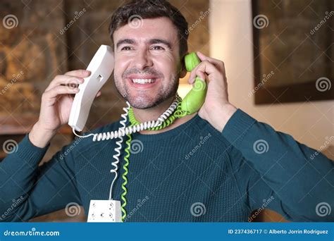 Messy Man Using Two Landline Telephones At The Same Time Stock Image