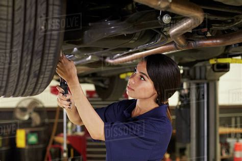 Female auto mechanic working underneath car in garage - Stock Photo ...
