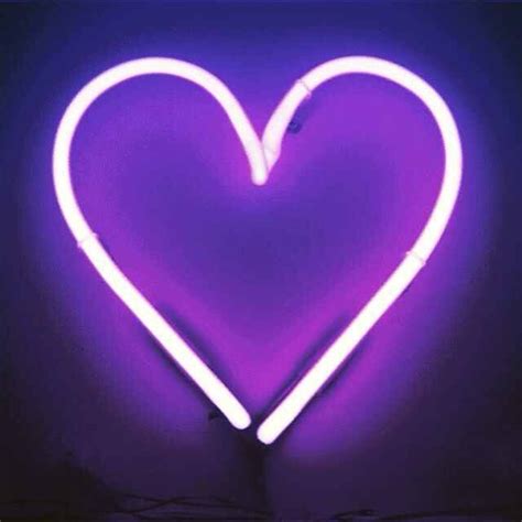 A Purple Heart Shaped Neon Sign In The Dark With White Lights On Its Sides