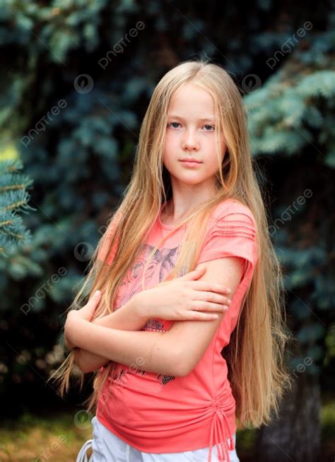 فتاة شقراء طويلة الشعر في سن المراهقة تتظاهر في الهواء الطلق صورة الخلفية والصورة للتنزيل