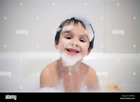 Cute Boy In Bathtub Evening Time Smiling Covered With Soap Foam Stock
