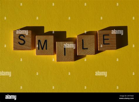 Smile Word In Wooden Alphabet Letters Isolated On Bright Yellow