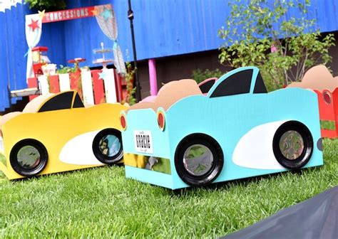 Three Cardboard Cars Are Sitting In The Grass