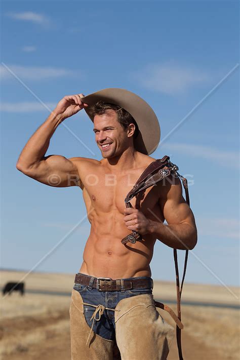 Shirtless Muscular Cowboy Smiling And Lifting His Hat On A Ranch ROB