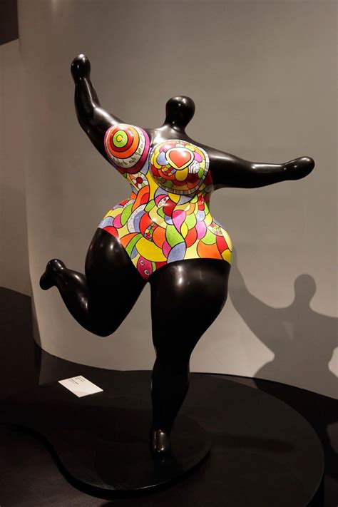 A Statue Of A Woman In A Colorful Bathing Suit Is On Top Of A Black Table