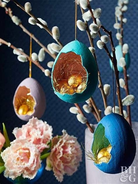 An Arrangement Of Easter Eggs Hanging From Branches With Flowers In Vases Behind Them On A Blue Wall