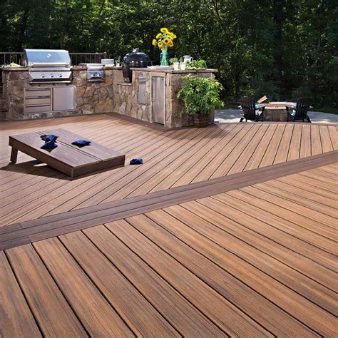 A Wooden Deck With Grills And Chairs Around It