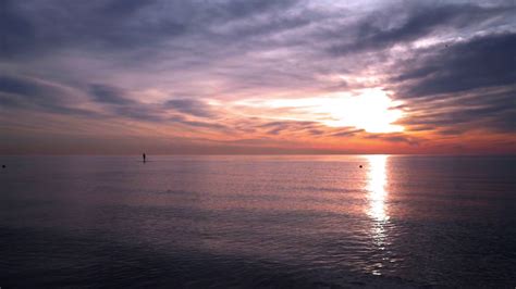 Ocean sunset. Man on surfboard at sunset ocean. Sunset at ocean with calm water. Sunset ocean ...