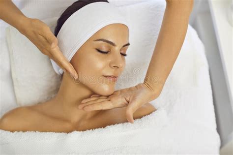 Hands Of Cosmetologist Making Facial Beauty Massage For Relaxed Lying Young Woman Stock Image