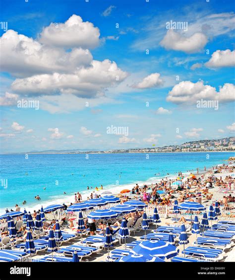 Tourists Sunbeds And Umbrellas On Summer Hot Day On The Beach Nice
