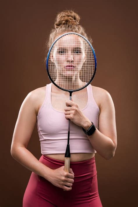 Young Female Tennis Player Holding Racket In Front Of Her Face In