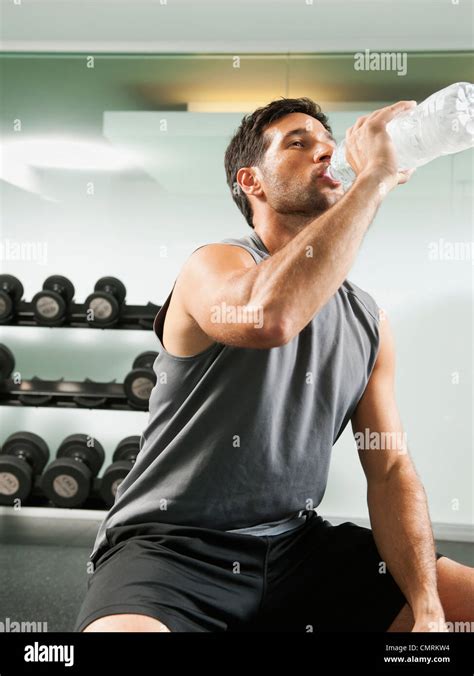 Mixed Race Man Drinking Water In Gym Stock Photo Alamy