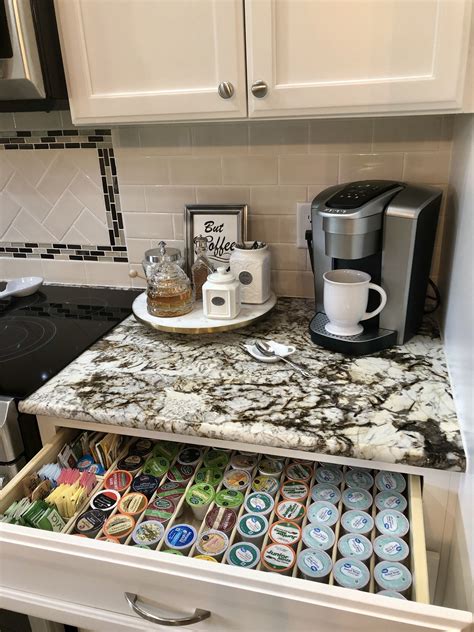 An Open Drawer In A Kitchen Filled With Magnets And Coffee Cups On The