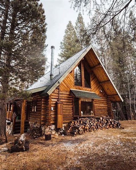 A Log Cabin In The Woods With Logs Stacked Outside