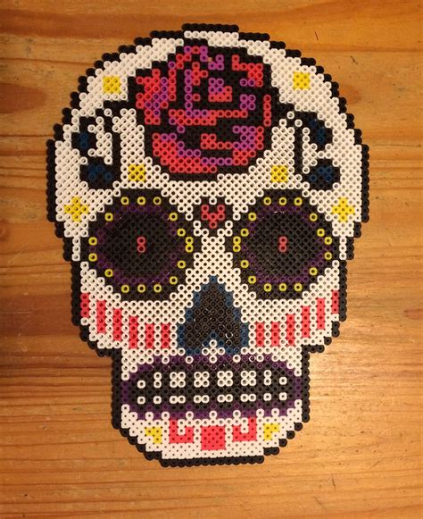 This tutorial shows you how to create a basic and simple skull shaped outline using fused beads such as hama and perler varieties on a small square pegboard. Perler Bead Sugar Skull Door Hanger | Perler beads designs ...