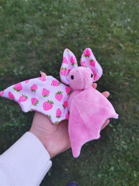 A Handmade Plush Bat Made Of Pink Fabric With Strawberry Accent Fabric