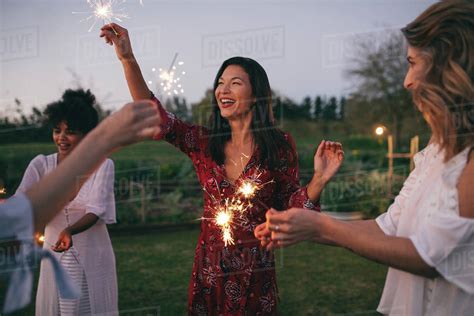 Multi Ethnic Group Of Friends Enjoying Party With Sparklers Women Having Fun With Sparklers