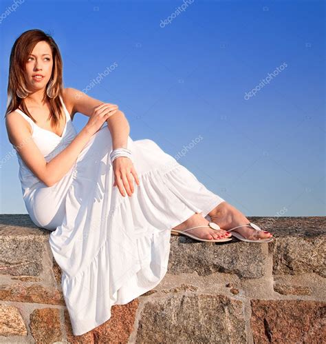 Lady Sitting On Top Of A Stone Wall Stock Photo Cybernesco