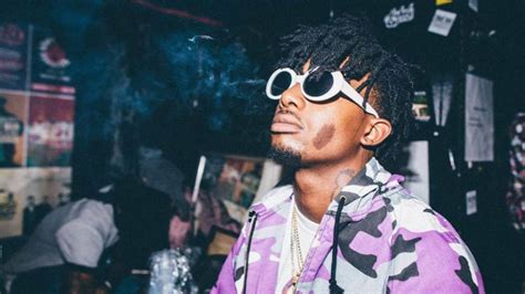 Playboi Carti Is Looking Up Wearing Purple And Black Coat