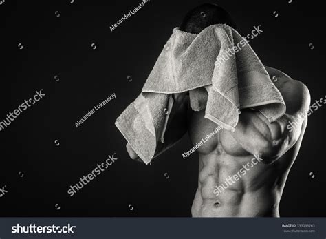 Bodybuilders Towel Body After A Tiring Workout Against A Dark