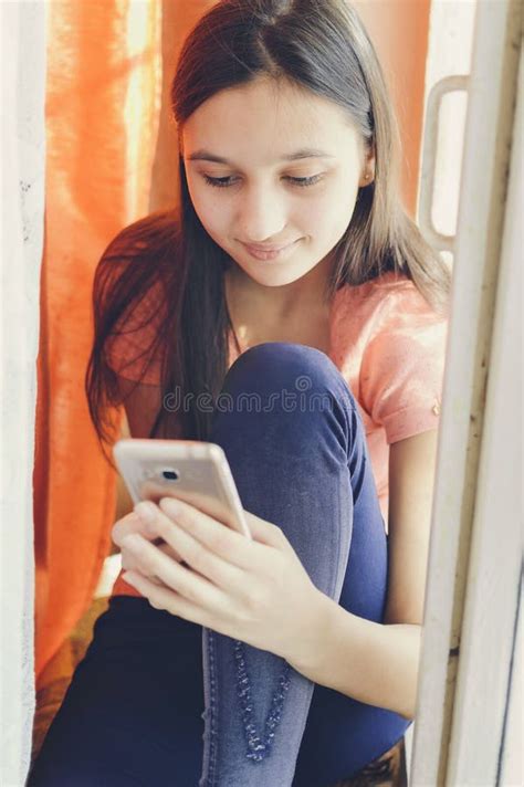 Menina Adolescente Bonita Que Guarda Um Telefone Celular Estilo Do Estilo De Vida Foto De Stock