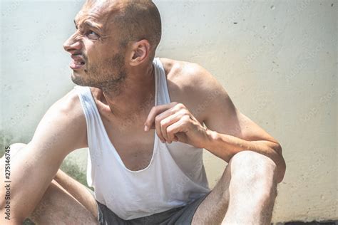 Young Poor Skinny Anorexic Bald Homeless Man Sitting On The Urban