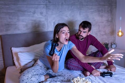 Premium Photo Couple Having Fun Playing Video Games In Bed