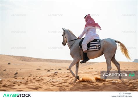توارث حب الجياد من الأجداد ونشره بين أبناء الوطن، فارس عربي خليجي سعودي يمتطي فرسه في الصحراء