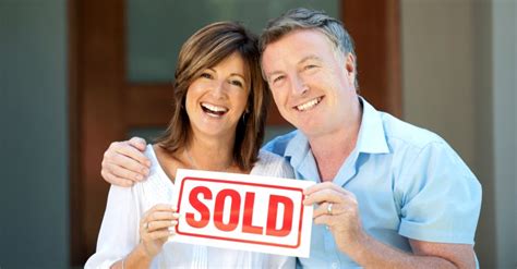 Happy Mature Couple Holding Sold Sign Sell My House Fast