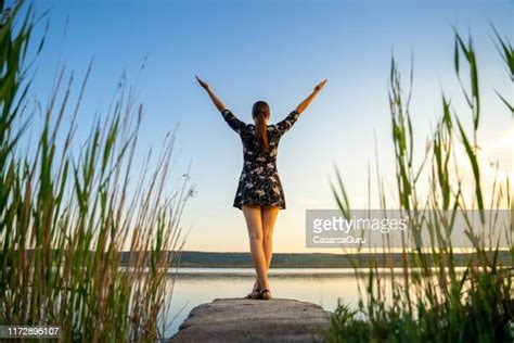 Woman Standing On Beach With Arms Up Rear View Bildbanksfoton Och
