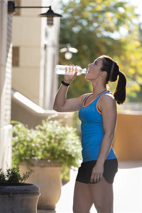 Beautiful Brunette Woman Drinking Water After Exercise Stock Image