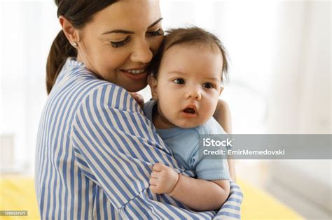 Portrait Of Beautiful Young Mother Holding Her Baby Boy Stock Photo