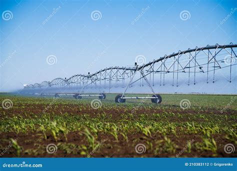 Modern Agricultural Irrigation System Spraying In Field Stock Photo