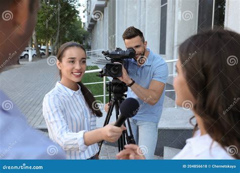 Professional Journalist And Operator With Video Camera Taking Interview